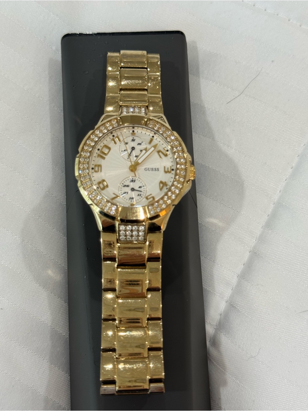 Guess gold tone watch with stones .